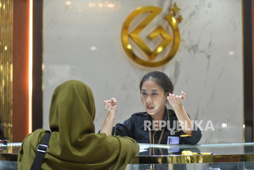 Karyawan melayani pembeli di Galeri24 Pegadaian, Jakarta Selasa (11/1/2022).
