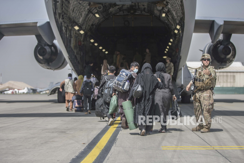  Dalam gambar yang disediakan oleh Korps Marinir AS, keluarga mulai menaiki Boeing C-17 Globemaster III Angkatan Udara AS selama evakuasi di Bandara Internasional Hamid Karzai di Kabul, Afghanistan, Senin, 23 Agustus 2021.