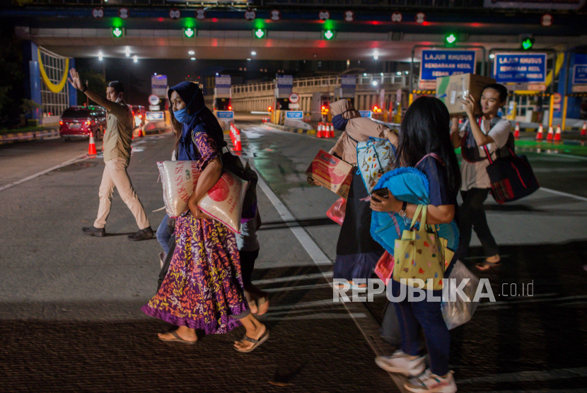 Sejumlah pemudik dari Jakarta menunggu bus untuk dipulangkan kembali ke Jakarta di Gerbang Tol Cikarang Barat, Bekasi, Jawa Barat, Sabtu (23/5) dini hari. Sekitar 200 pemudik yang menggunakan jasa travel tanpa izin beserta kendaraan pribadi terkena razia penyekatan dan akan dikembalikan ke Jakarta