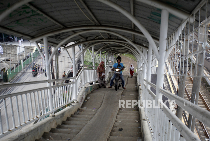 Pengendara sepeda motor melewati Jembatan Penyeberangan Orang (JPO).