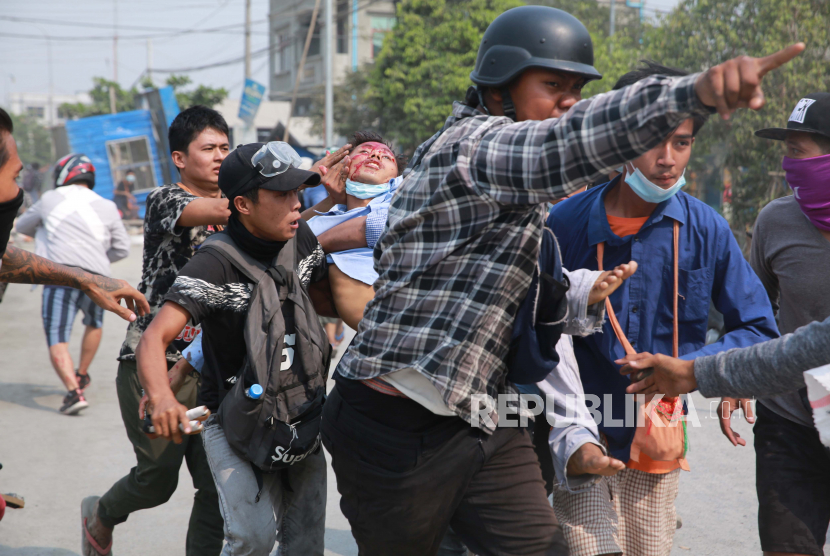 Seorang pria dengan cedera kepala digendong oleh pria lain Senin 22 Maret 2021 di Mandalay, Myanmar. BBC mengatakan Senin bahwa seorang jurnalis dari layanan berbahasa Burma dibebaskan oleh pihak berwenang di Myanmar tetapi tidak memberikan rincian, karena pengunjuk rasa di negara Asia Tenggara itu melanjutkan gerakan pembangkangan sipil mereka yang luas terhadap kudeta militer bulan lalu.