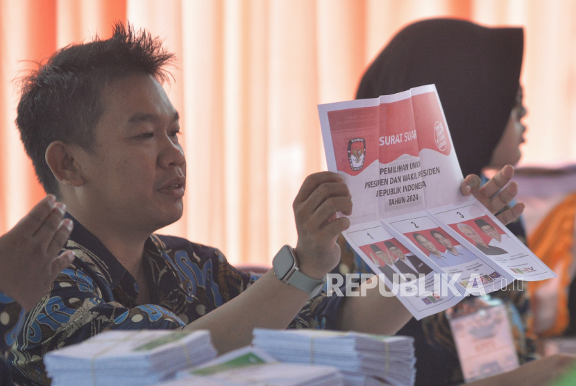 Petugas TPS menunjukan kertas suara kepada warga menggunakan hak pilihnya pada Pemilu 2024.