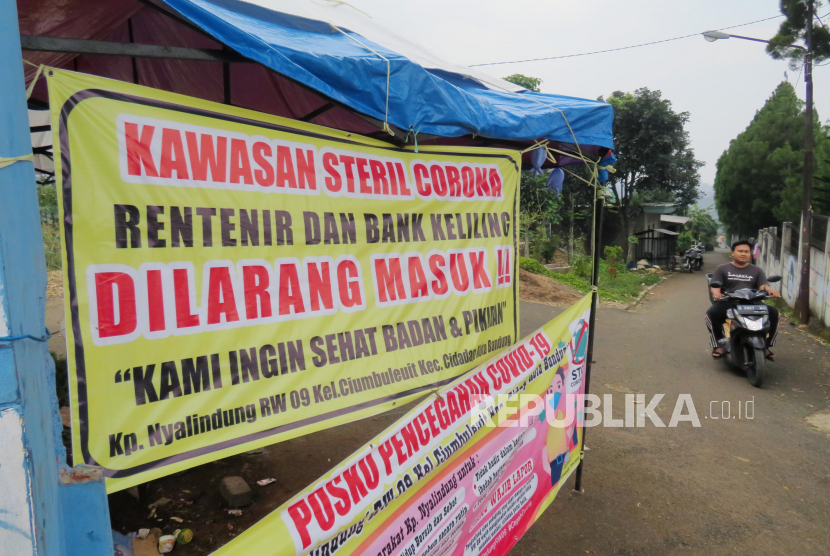 Sebuah sepanduk berisi peringatan rentenir dan bank keliling dilarang masuk dipasang di salah satu gang di kawasan Punclut, Kota Bandung, Senin (20/4). Pemasangan sepaduk serupa banyak dilakukan masyarakat sebagai upaya melindungi warga yang terdampak Covid-19 terjebak masalah rentenir.