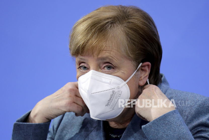  Kanselir Jerman Angela Merkel melepas topengnya pada awal konferensi pers setelah bertemu dengan produsen vaksin dan perdana menteri negara Jerman melalui konferensi video, di Berlin, Jerman, Senin 1 Februari 2021.