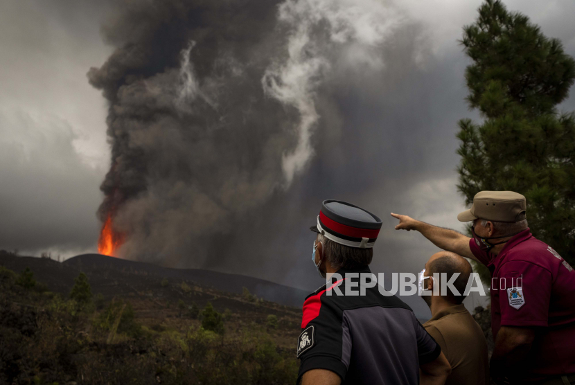  Petugas polisi dan petugas kota melihat lava dari letusan gunung berapi yang mengalir di pulau La Palma di Canaries, Spanyol, Rabu, 22 September 2021. 