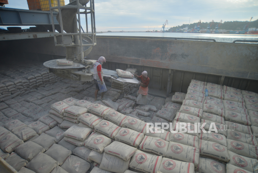 Pekerja memindahkan karung semen ke atas kapal, di dermaga Semen Padang, Teluk Bayur, Padang, Sumatera Barat, Rabu (24/11/2021). PT Semen Indonesia Tbk (SMGR) pada tahun 2021 kemarin mengantongi pendapatan sebesar Rp 34,94 triliun. 