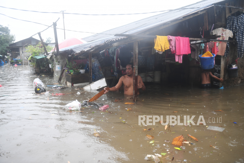 Warga membersihkan sampah yang terbawa air saat banjir merendam kawasan RW 5, Duren Tiga, Pancoran, Jakarta, Kamis (18/2/2021). Sejumlah kawasan di Jakarta terendam banjir akibat curah hujan yang tinggi. 