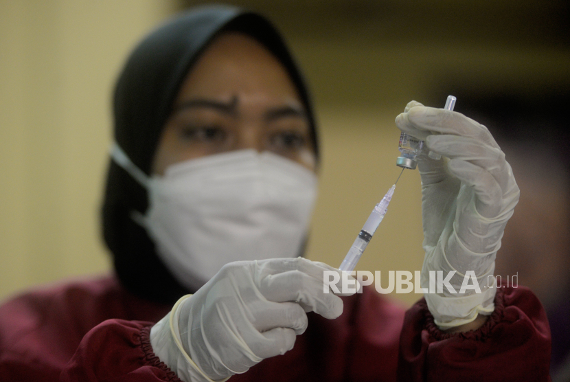 Tenaga kesehatan menyiapkan vaksin Covid-19 untuk disuntikan kepada warga di GOR Kampung Makasar, Jakarta,  Jumat (12/11).