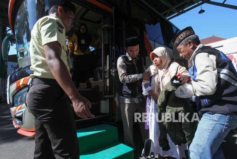 Dua petugas membantu seorang calon haji memasuki bus saat keberangkatan di Asrama Haji Embarkasi Surabaya (AHES), Surabaya, Jawa Timur, Ahad(19/5/2024). Pihak Panitia Penyelenggara Ibadah Haji (PPIH) Embarkasi Surabaya mencatat sejak Sabtu (11/5)  telah memberangkatkan kloter 1 sampai kloter 31 dengan jumlah 11.496 calon haji.