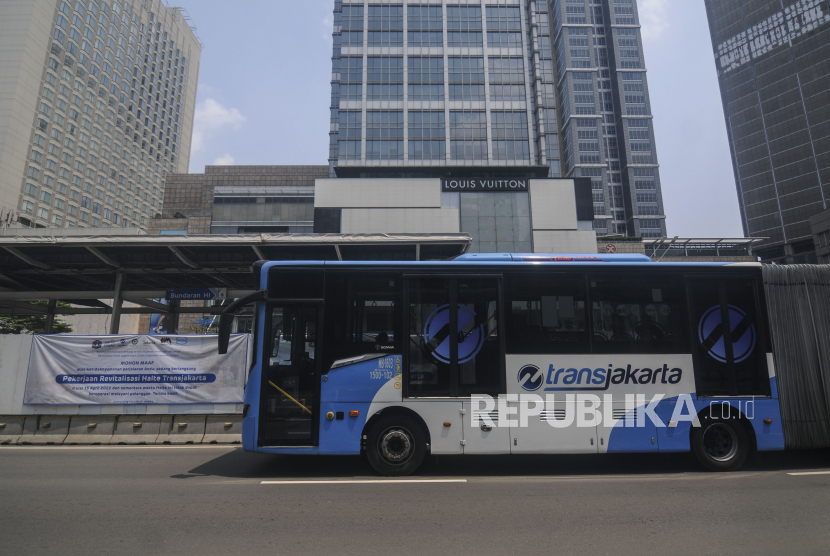 Bus Transjakarta melintas di dekat Halte Bundaran HI yang sedang dibongkar di Jakarta, Ahad (17/4/2022). 