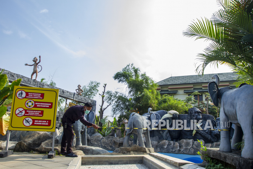 Petugas keamanan menutup salah satu wahana wisata Wonderland Adventure Waterpark di kawasan Galuh Mas, Karawang, Jawa Barat,  Ahad (20/6/2021). Pemerintah Kabupaten Karawang berencana menutup sementara seluruh objek wisata selama dua pekan guna menekan peningkatan kasus penularan dan penyebaran COVID-19. 