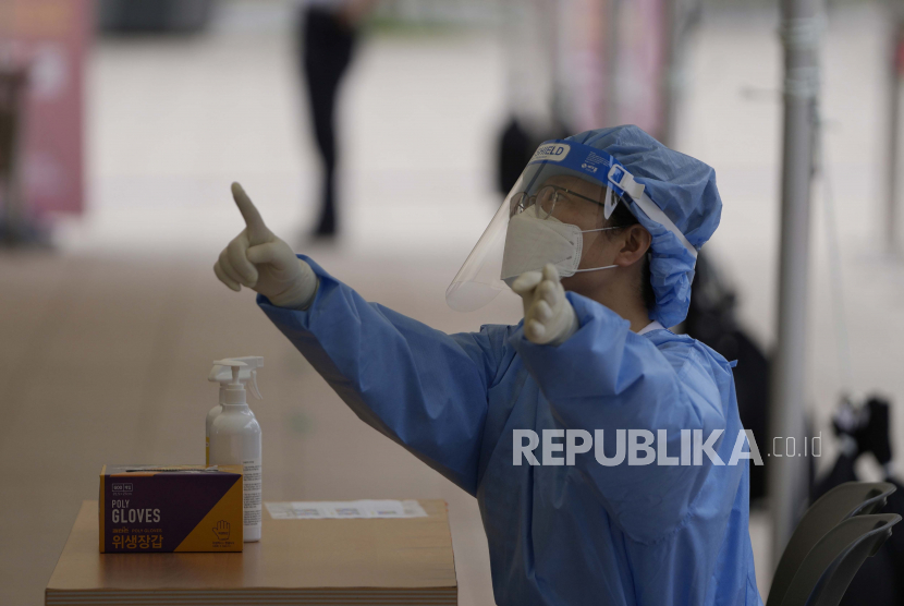 Seorang pekerja medis mengenakan alat pelindung diri untuk pengujian COVID-19 di tempat pengujian virus corona di Seoul, Korea Selatan, Senin, 12 Juli 2021