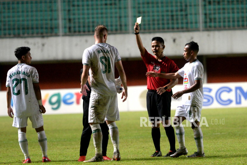 Wasit Iwan Sukoco memberikan kartu kuning untuk bek PSS Mario Maslac saat melawan Persib pada pertandingan Semifinal Pertama Piala Menpora 2021 di Stadion Maguwoharjo, Sleman, Yogyakarta, Jumat (16/4) malam. Pada pertandingan Semifinal pertama ini Persib berhasil mengalahkan PSS 2-1.