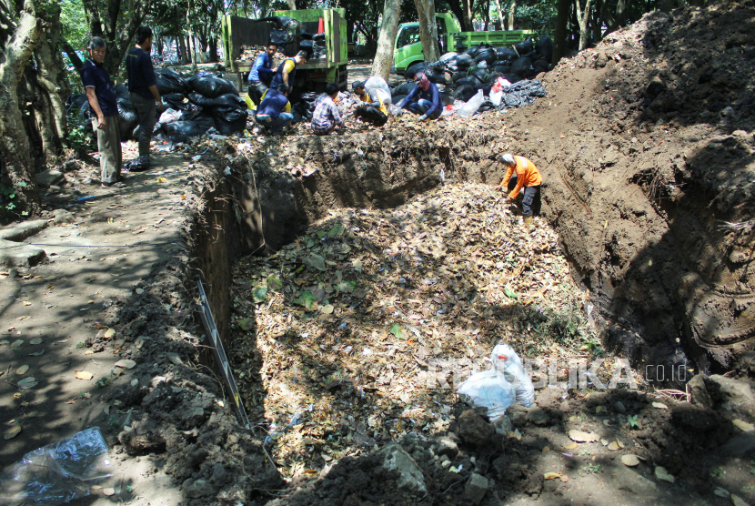 Petugas memasukkan sampah organik ke dalam lubang yang telah disiapkan di kawasan Taman Tegallega, Kota Bandung, Jawa Barat, Kamis (31/8/2023). 