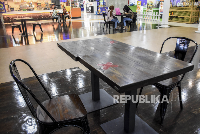 Pengunjung menunggu pesanan makanan di pusat jajanan serba ada (Food Court) di Bandung Indah Plaza, Jalan Merdeka, Kota Bandung, Kamis (12/8). Pemerintah Kota Bandung kembali mengizinkan pusat perbelanjaan, restoran dan kafe untuk melayani makan di tempat (dine-in) selama perpanjangan PPKM Level 4 hingga 16 Agustus dengan berbagai syarat diantaranya, membatasi jumlah pengunjung sebanyak 25 persen dari kapasitas, pengunjung dan pegawai sudah disuntik vaksin Covid-19 minimal dosis pertama serta pembatasan waktu hingga pukul 20.00 WIB.