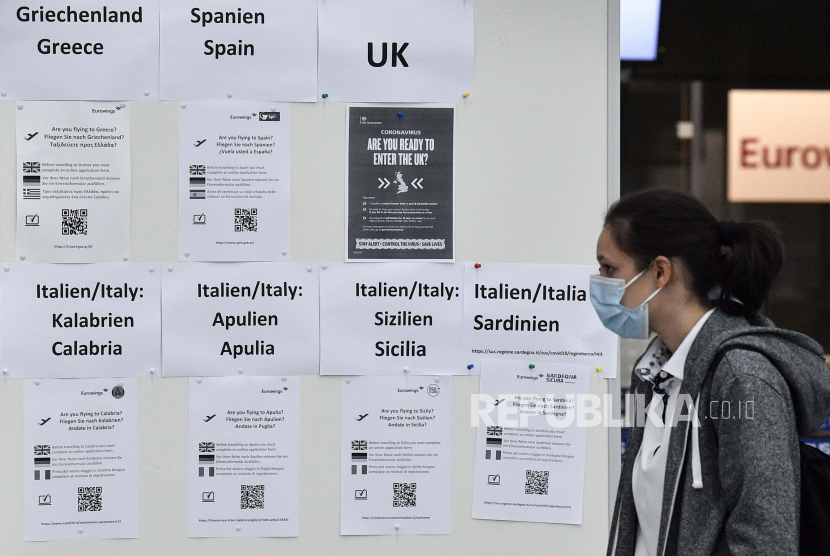 Seorang penumpang membaca informasi untuk bepergian ke Yunani, Italia, Spanyol dan Inggris di bandara Duesseldorf, Jerman, Senin, 27 Juli 2020. Pusat-pusat pengujian baru untuk coronavirus didirikan di bandara Jerman karena pandemi, uji korona gratis diberikan untuk mereka yang kembali dari negara-negara yang ditunjuk sebagai daerah berisiko.