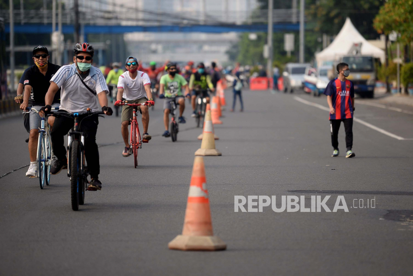 Warga berolahraga saat Hari Bebas Kedaraan Bermotor (HBKB) atau Car Free Day (CFD) di Jalan Gajah Mada, Jakarta, Ahad (28/6). Pemprov DKI Jakarta menggelar HBKB di 32 lokasi baru untuk menggantikan HBKB yang ditiadakan di jalan Sudirman-Thamrin dengan alasan menghindari terjadinya krumunan warga untuk mencegah penyebaran Covid-19.Prayogi/Republika