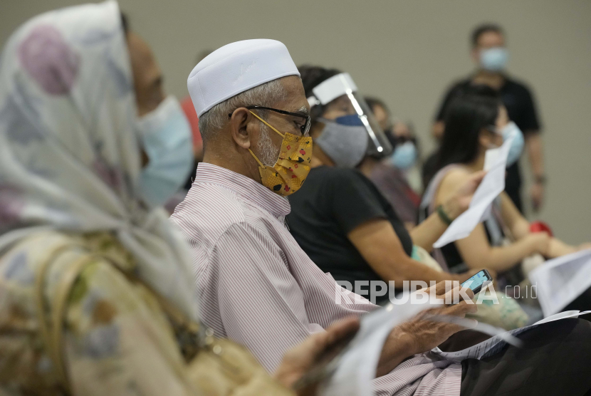 Warga yang mengenakan masker dan pelindung wajah menunggu vaksin virus corona Pfizer di pusat vaksinasi di Kuala Lumpur, Malaysia.