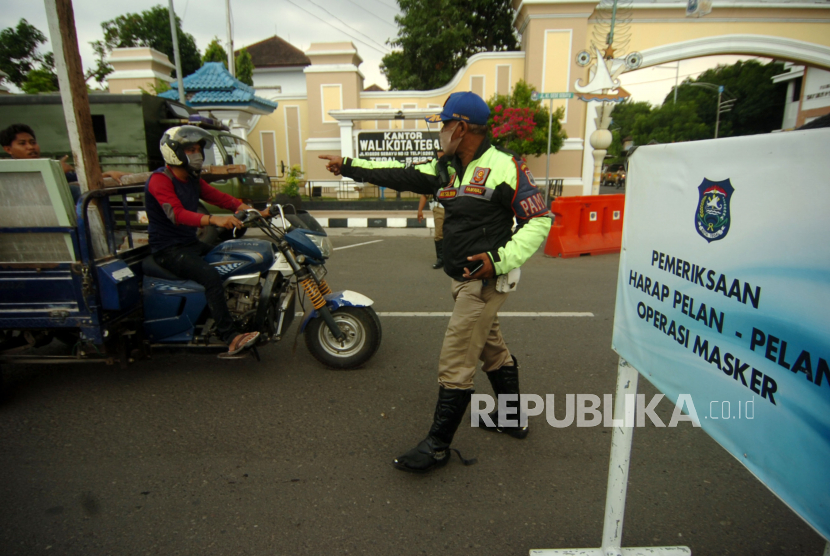 Petugas Satpol PP memberhentikan kendaraan saat razia yustisi di Alun-alun Tegal, Jawa Tengah, Senin (4/1/2021). Operasi Yustisi tersebut untuk menertibkan masyarakat agar lebih disiplin dalam menerapkan protokol kesehatan di Kota Tegal karena kasus COVID-19 yang semakin meningkat. 