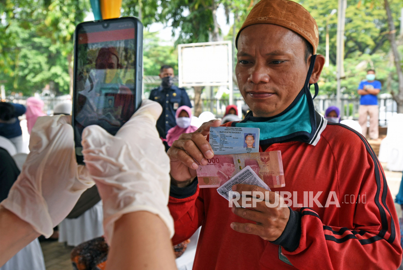 Warga penerima manfaat bantuan sosial tunai difoto petugas di Kantor Pos Serang, Banten, Rabu (6/5/2020). Bansos berupa uang tunai Rp600 ribu per KK per bulan diberikan kepada keluarga miskin dan rentan miskin dampak pandemi COVID-19 selama tiga bulan ke depan