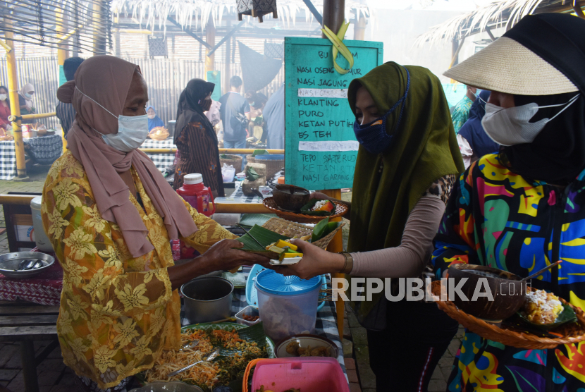 Penjual dan pembeli bertransaksi di Pasar Pundensari, Desa Wisata Gunungsari, Kabupaten Madiun, Jawa Timur, Ahad (11/4/2021). Pemerintah optimistis ekonomi Indonesia dapat tumbuh di kisaran 4,5 persen hingga 5,3 persen pada 2021. 