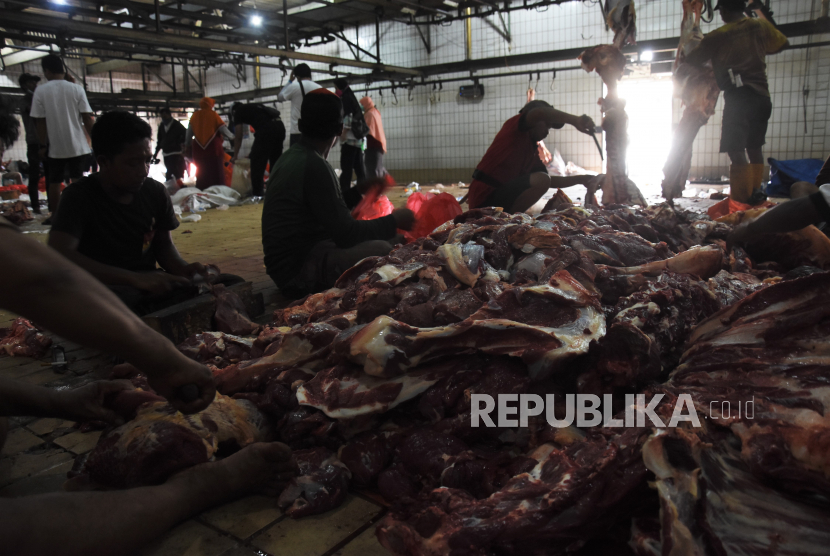 Pekerja memotong daging sapi kurban di Rumah Pemotongan Hewan (RPH) PD. Dharma Jaya, Cakung, Jakarta.