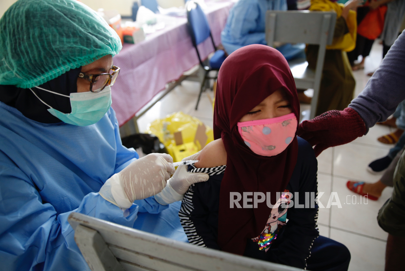  Seorang dokter memvaksinasi seorang gadis muda di sebuah sekolah dasar Muslim di Depok, Indonesia, 20 November 2020. Banyak sekolah di Indonesia memberikan vaksin campak, difteri dan tetanus, kepada siswa sekolah dasar di tengah pandemi virus corona yang sedang berlangsung.