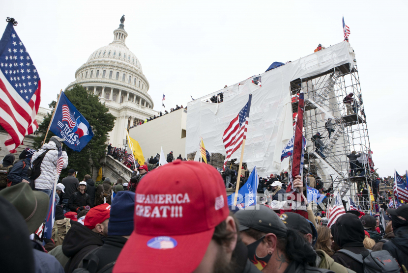 Pendukung Presiden Donald Trump naik ke platform pelantikan di Front Barat Capitol AS pada Rabu, 6 Januari 2021, di Washington.