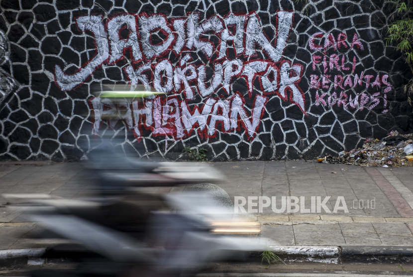 Pengendara melintas di dekat mural yang bertuliskan Jadikan Koruptor Pahlawan di Jalan Perintis Kemerdekaan, Sumur Bandung, Kota Bandung, Senin (30/8). Mural tersebut merupakan bentuk ekspresi dari sejumlah seniman sekaligus media penyampaian kritik dan sindiran terhadap perilaku korupsi di Indonesia. Foto: Republika/Abdan Syakura