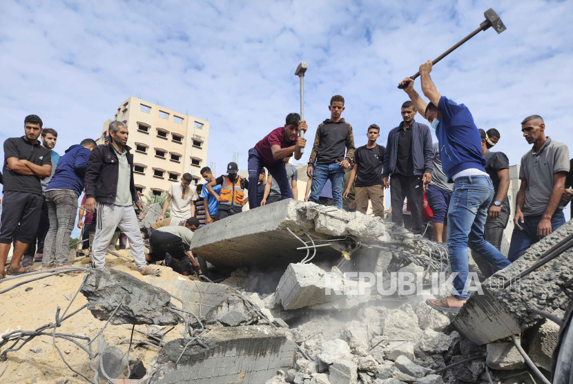 Orang-orang Palestina bekerjasama mencari warga yang selamat dari puing-puing akibat aksi ledakan yang dilakukan Israel di Gaza, Selasa (17/10/2023). 
