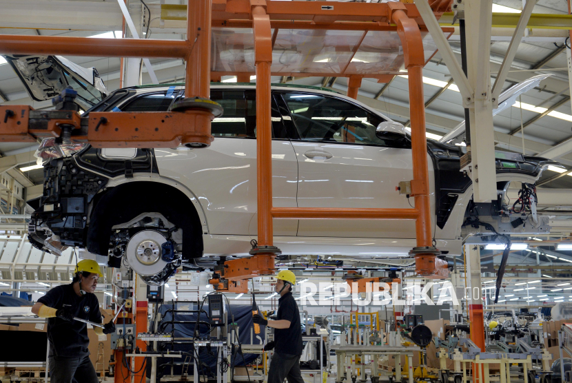 Pekerja menyelesaikan perakitan dan pengecekan mobil di Indonesia.