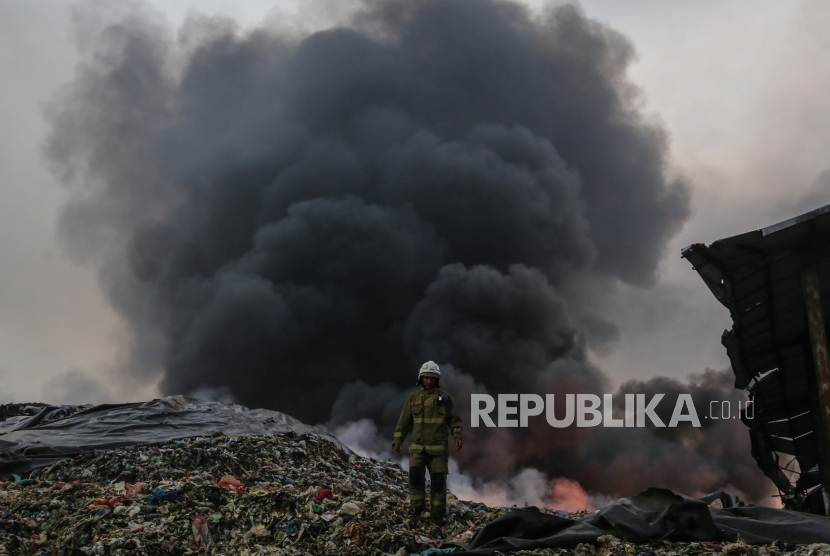 Petugas pemadam kebakaran berjalan di tempat pembuangan akhir (TPA) Jatibarang yang terbakar di Semarang, Jawa Tengah.