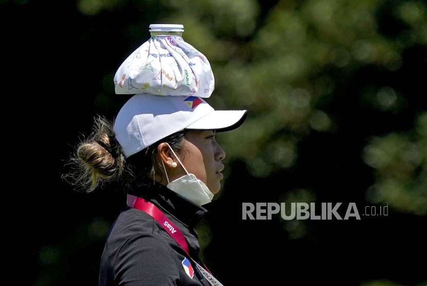 Bianca Pagdanganan, dari Filipina, mengenakan kompres es di kepalanya agar tetap dingin selama putaran latihan sebelum pertandingan golf putri di Olimpiade Musim Panas 2020, Selasa, 3 Agustus 2021, di Kasumigaseki Country Club di Kawagoe, Jepang .