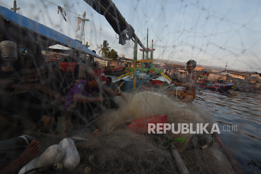 Nelayan memperbaiki jaring di atas perahunya di perkampungan nelayan Cilincing, Jakarta. Sekjen Koalisi Rakyat untuk Keadilan Perikanan (Kiara) Susan Herawati mengatakan pemerintah diharapkan memberikan perhatian kepada nelayan dan pelaku perikanan rakyat.