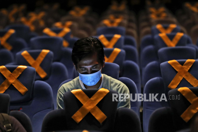  Orang-orang duduk terpisah di tengah penanda jarak fisik saat mereka menunggu dimulainya film di bioskop CGV Cinemas di Jakarta, Indonesia, Jumat, 23 Oktober 2020. Bioskop tersebut dibuka kembali minggu ini setelah ditutup berbulan-bulan karena wabah virus corona.