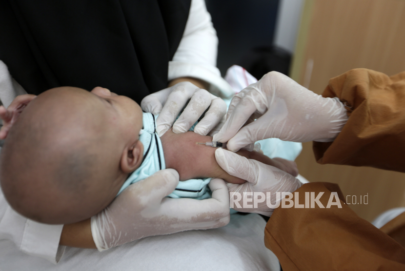  Seorang perawat memakai peralatan medis pelindung saat dia memberi vaksin imunisasi kepada balita selama program vaksinasi door to door melawan polio, campak dan rubella di tengah pandemi COVID-19 di Banda Aceh,  Rabu (7/8/2020).  
