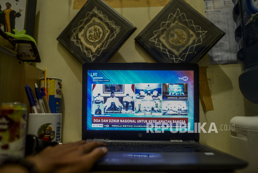 Seorang warga menonton siaran Dzikir Nasional secara streaming di Jakarta, Kamis (16/4). Satgas Covid-19 Majelis Ulama Indonesia bersama BNPB, Kantor Wakil Presiden, Kementerian Agama, Kementerian Komunikasi dan Informatika mengadakan Dzikir Nasional yang diselenggarakan secara streaming untuk menolak musibah pandemi Covid-19