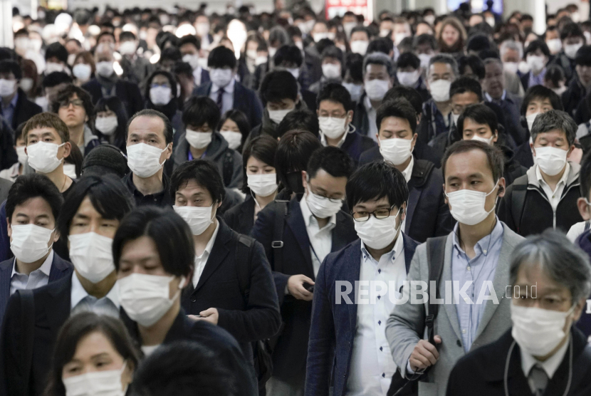 Sejumlah pekerja kantoran mengenakan masker untuk menghindari infeksi coronavirus usai menaiki kereta komuter yang penuh sesak di stasiun kereta api, Tokyo, Jepang, Senin (6/4). Perdana Menteri Jepang Shinzo Abe direncanakan akan mengumumkan keadaan darurat pada 07 April 2020 atas wabah COVID-19