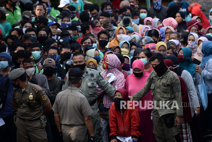 Warga antre sembako di gedung Baznas Kabupaten Bogor, Cibinong, Jabar, Senin (20/4). Ratusan warga rela mengantre dan tidak mepedulikan physical distancing untuk mendapatkan 5 kg beras dan 10 bungkus mie instan