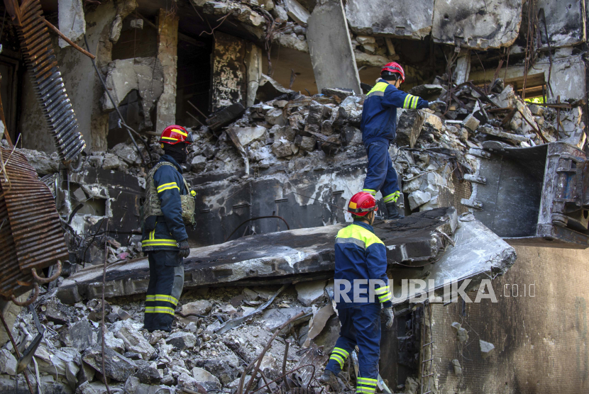 Personel layanan darurat Ukraina bekerja di luar gedung yang rusak setelah penembakan, di Kharkiv, Ukraina, Sabtu, 4 Juni 2022.