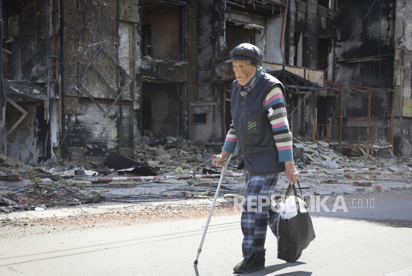  Presiden Polandia: Ukraina Berhak Menentukan Nasibnya Sendiri. Foto:  Seorang warga berjalan melewati sebuah rumah yang hancur di Mariupol, di wilayah di bawah pemerintahan Republik Rakyat Donetsk, Ukraina timur, Selasa, 17 Mei 2022.