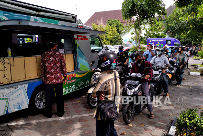 Warga menggunakan kendaraan antre membuat KTP elektronik dengan drive thru di Balai Kota Yogyakarta, Kamis (2/7). Layanan pencetakan KTP Elektronik dengan drive thru merupakan yang pertama di Yogyakarta. Warga bisa memanfaatkan ini pada Selasa, Rabu, dan Kamis. Dan di sini hanya melayani pencetakan KTP Elektronik rusak atau hilang. Sedangkan untuk perekaman baru atau perubahan data tetap dilayani di Dinas Kependudukan dan Pencatatan Sipil.