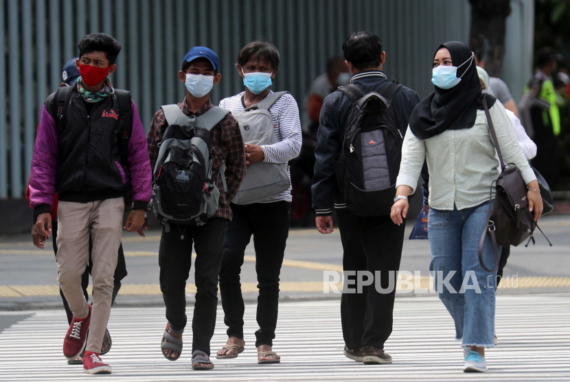 Warga mengenakan masker pelindung saat melintasi lalu lintas. Ilustrasi