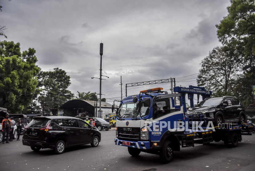 Petugas Dinas Perhubungan (Dishub) Kota Bandung menderek mobil yang parkir sembarangan. Plh Walkot Bandung Ema Sumarna sebut penertiban parkir liar dan PKL perlu dikaji.
