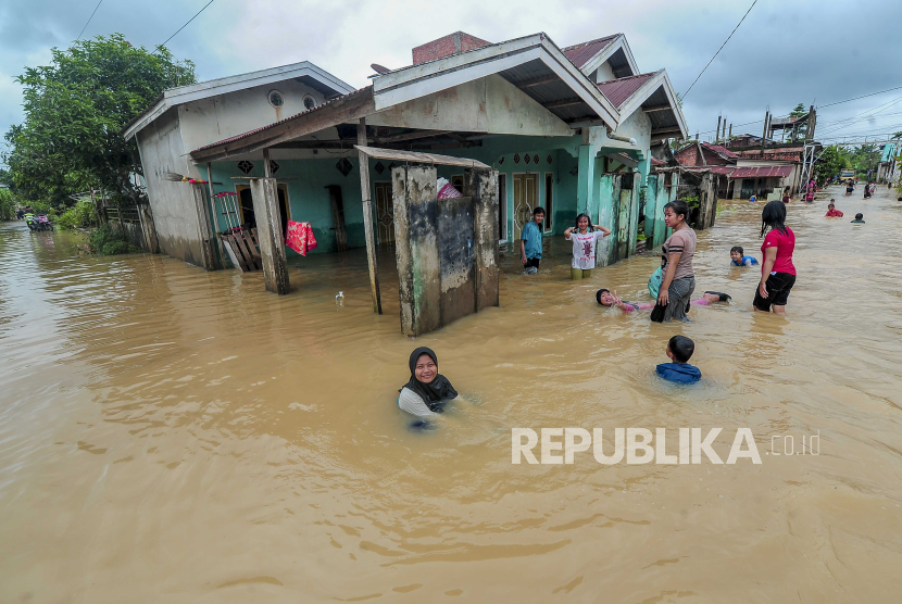 Remaja dan anak-anak bermain di kawasan permukiman yang terendam banjir di Pematang Gajah, Muaro Jambi, Jambi, Rabu (8/5/2024). Ratusan rumah di daerah perbatasan Kota Jambi dengan Kabupaten Muaro Jambi terendam banjir hingga sepinggang orang dewasa akibat hujan deras yang terjadi selama lima jam lebih pada Selasa (7/5) tengah malam hingga Rabu (8/5) dini hari dan diperparah dengan tidak berfungsinya saluran air. 