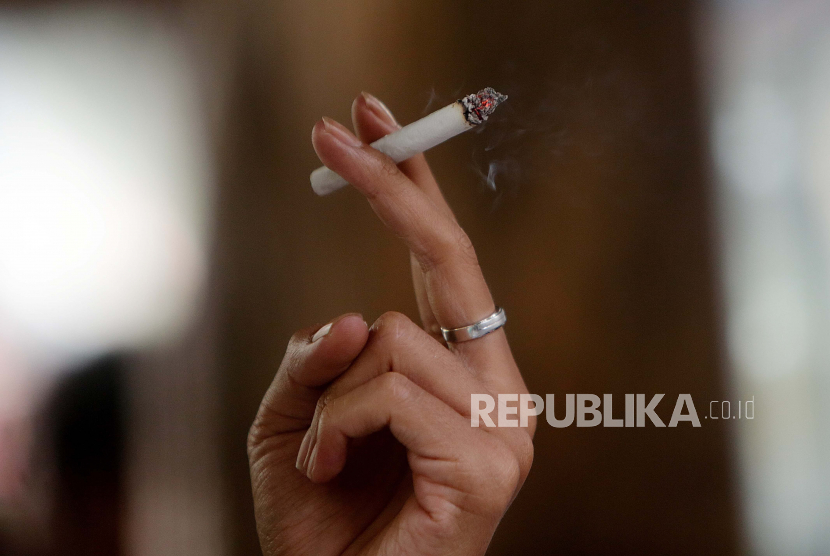 Seorang pria merokok di sebuah jalan di Jakarta. Sekretaris Jenderal Gerakan Nasional Anti Narkotika (Granat), Firman Soebagyo, menyebut penyetaraan tembakau dengan narkotika, psikotropika, dan minuman beralkohol dalam draf RUU Kesehatan tidak tepat. Sebab, menurut dia, adiksi narkoba tidak sama dengan tembakau.