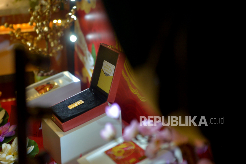 Petugas mengamati emas edisi imlek 2023 di Butik Emas Antam, Pulogadung , Jakarta, Senin (16/1/2023). Logam Mulia PT Aneka Tambang Tbk (Antam) kembali mengalami kenaikan pada Senin (14/3/2023).