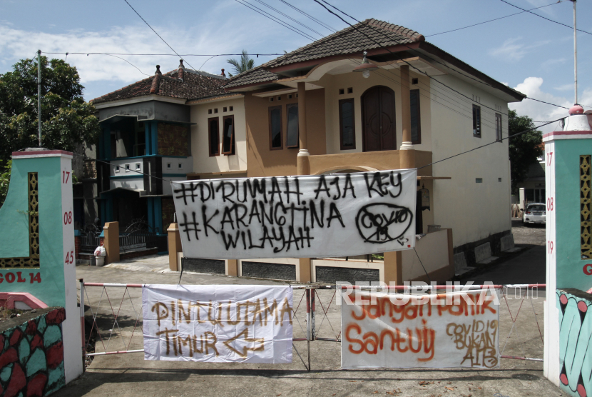 Warga melintas di depan spanduk penutupan jalan masuk Desa Kalasan, Sleman, DI Yogyakarta, Senin (30/3). Sejumlah desa atau perkampungan di Kota dan Kabupaten di DI Yogyakarta memberlakukan akses satu pintu masuk dengan menutup sejumlah jalan untuk mengurangi aktivitas warga sebagai upaya mencegah penularan COVID-19.