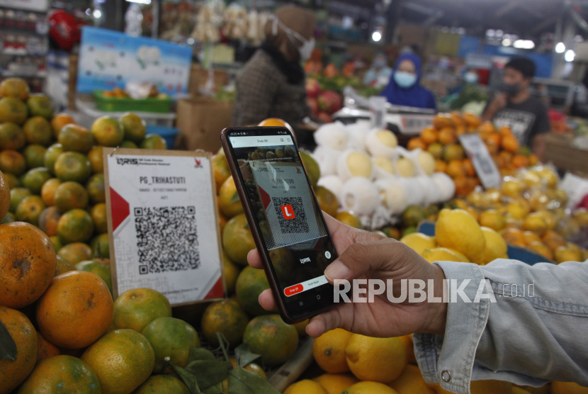 Pengunjung melakukan transaksasi digital dengan aplikasi pembayaran kepada pedagang di Pasar Gede Solo, Jawa Tengah, Jumat (3/9/2021). Bank Indonesia (BI) menyatakan digitalisasi pada sistem keuangan berdampak pada ekonomi yang tumbuh lebih cepat dibandingkan dengan cara konvensional.