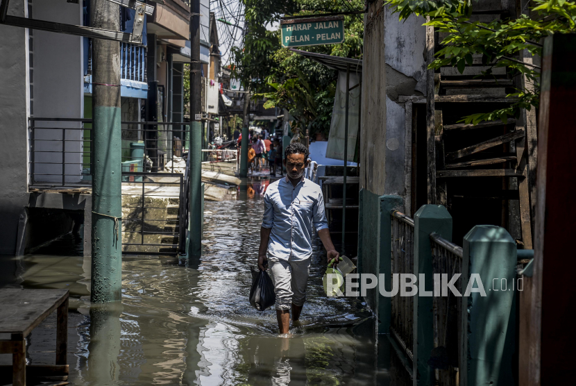 Warga melewati banjir di kawasan Kebon Jeruk, Jakarta, Selasa (22/9). Banjir yang merendam pemukiman warga tersebut diakibatkan meluapnya air di Kali Angke karena hujan deras yang mengguyur wilayah Jabodetabek pada Senin (22/9) malam. Republika/Putra M. Akbar